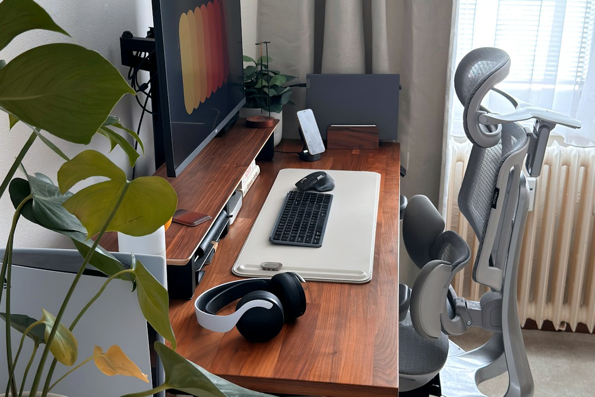 Split-screen comparison of multiple AI productivity tool interfaces on a modern desk setup with laptop and notebook
