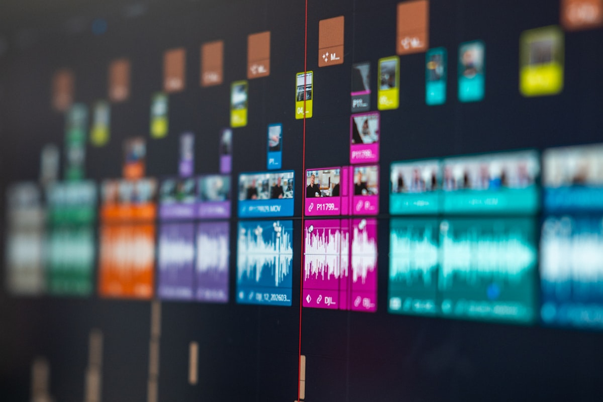 Computer monitor displaying video editing timeline at night with dark studio lighting