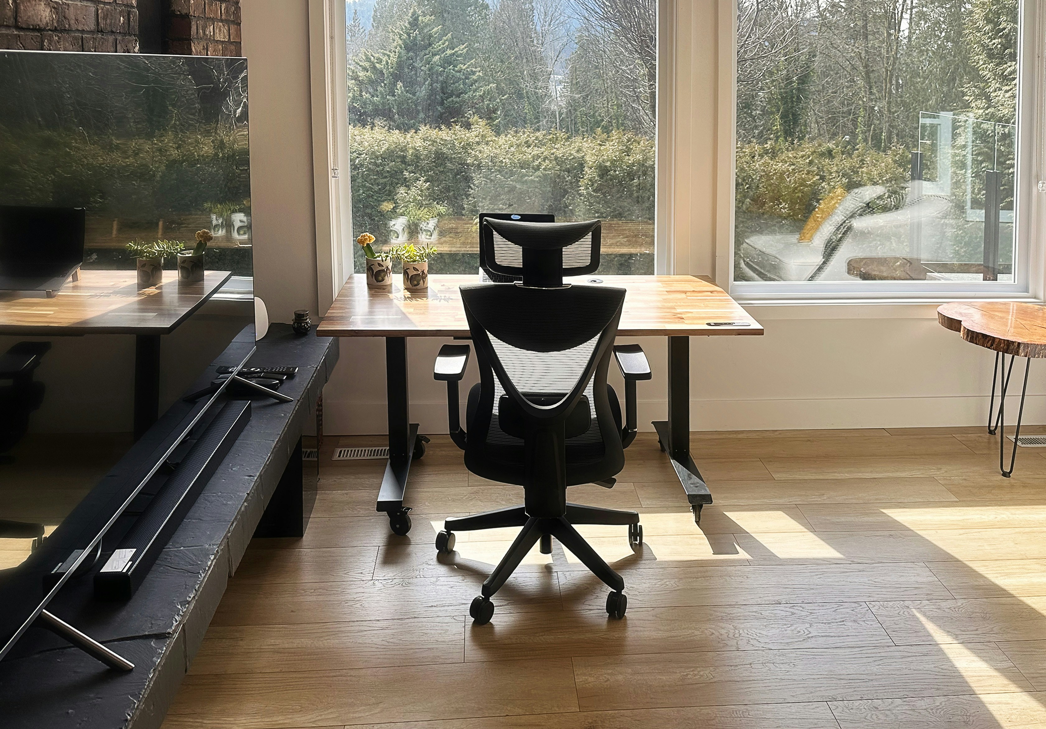 A modern home office workspace with an ergonomic chair on hardwood floors, a clean setup where a chair mat prevents caster damage long-term