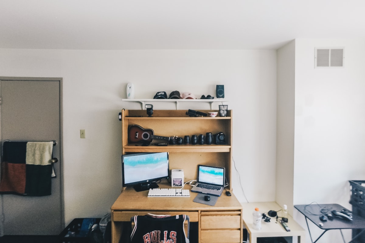Clean wooden desk setup with a monitor, keyboard, and no visible cable clutter