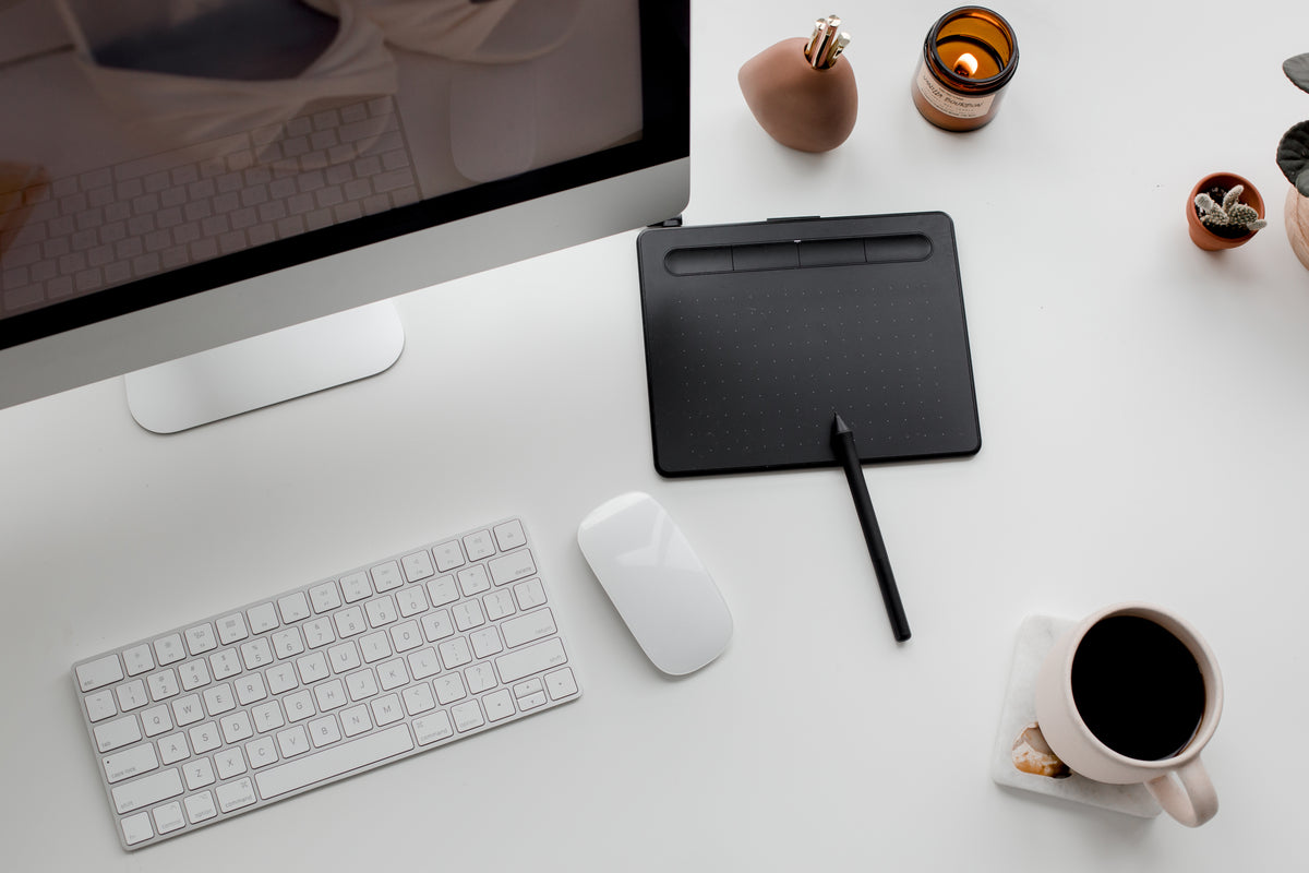 Single-cable Thunderbolt docking station on a clean dark desk setup with ultrawide monitor, mechanical keyboard, and no visible wires — one cable does everything