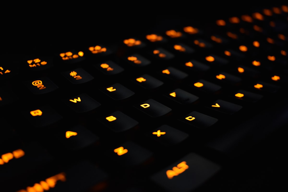 Close-up of a mechanical keyboard with orange LED backlit switches and keycaps