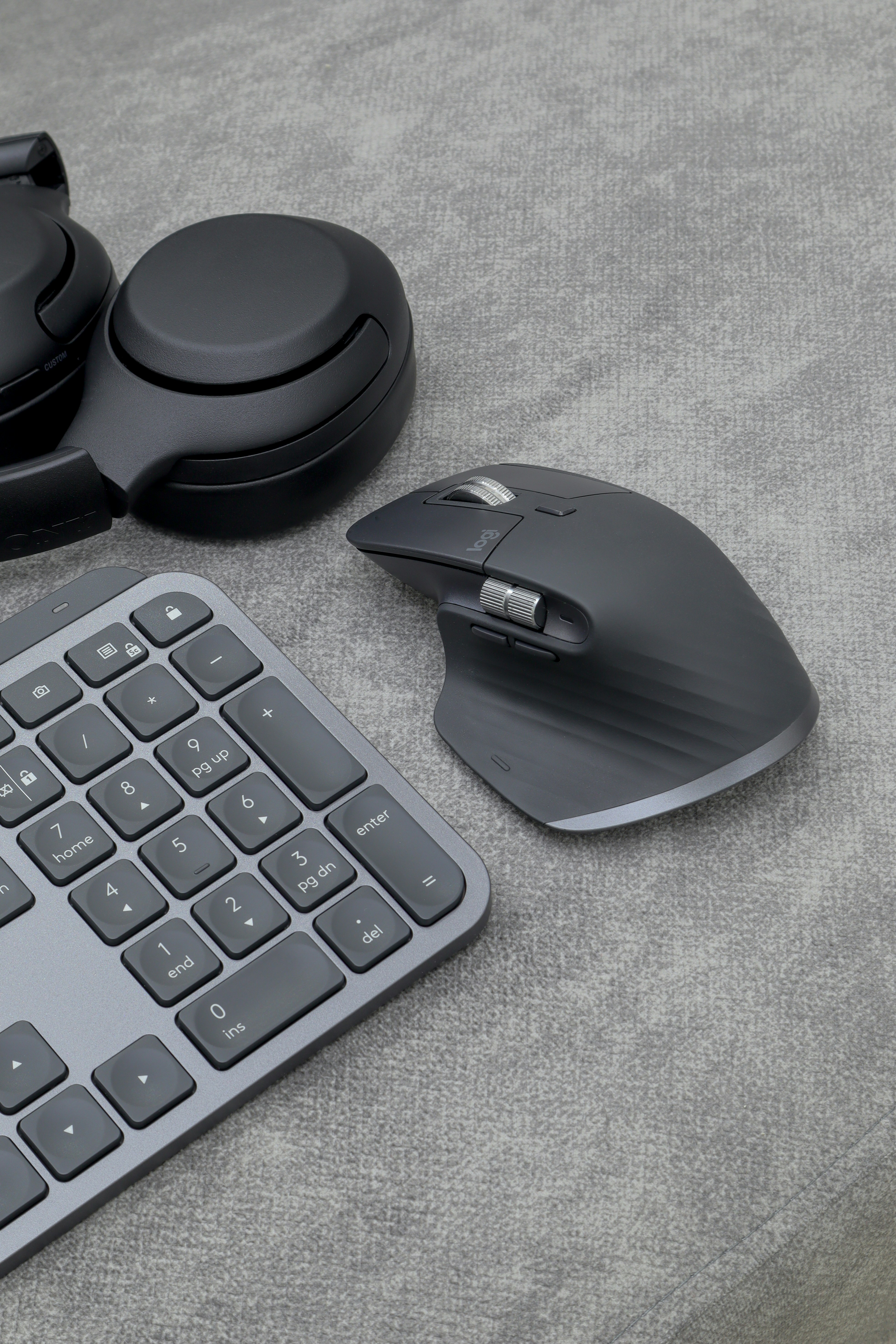 Vertical ergonomic mouse on a dark desk setup with mechanical keyboard and monitor in background