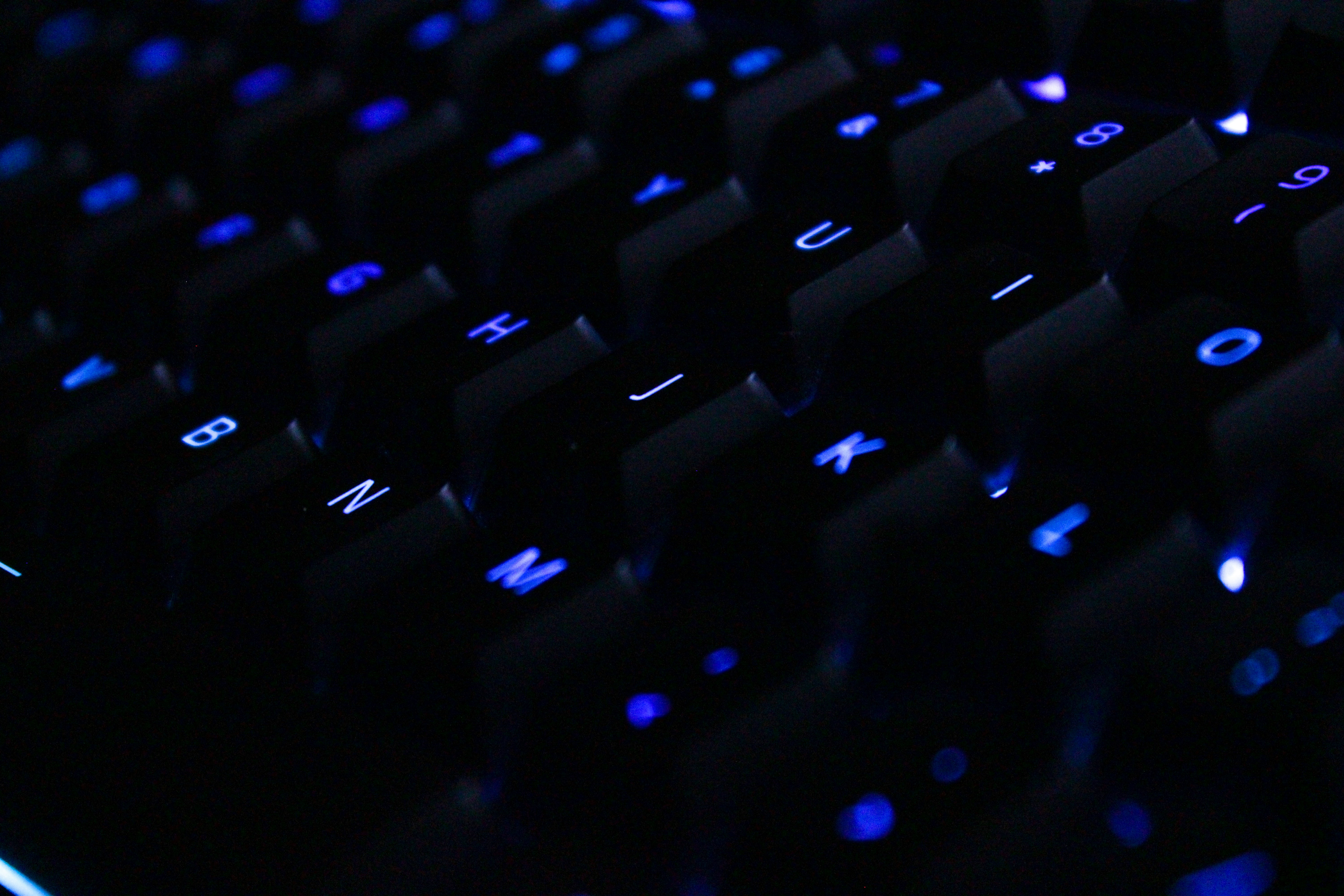 Wooting-style Hall Effect keyboard with dynamic RGB per-key lighting on a dark minimalist desk