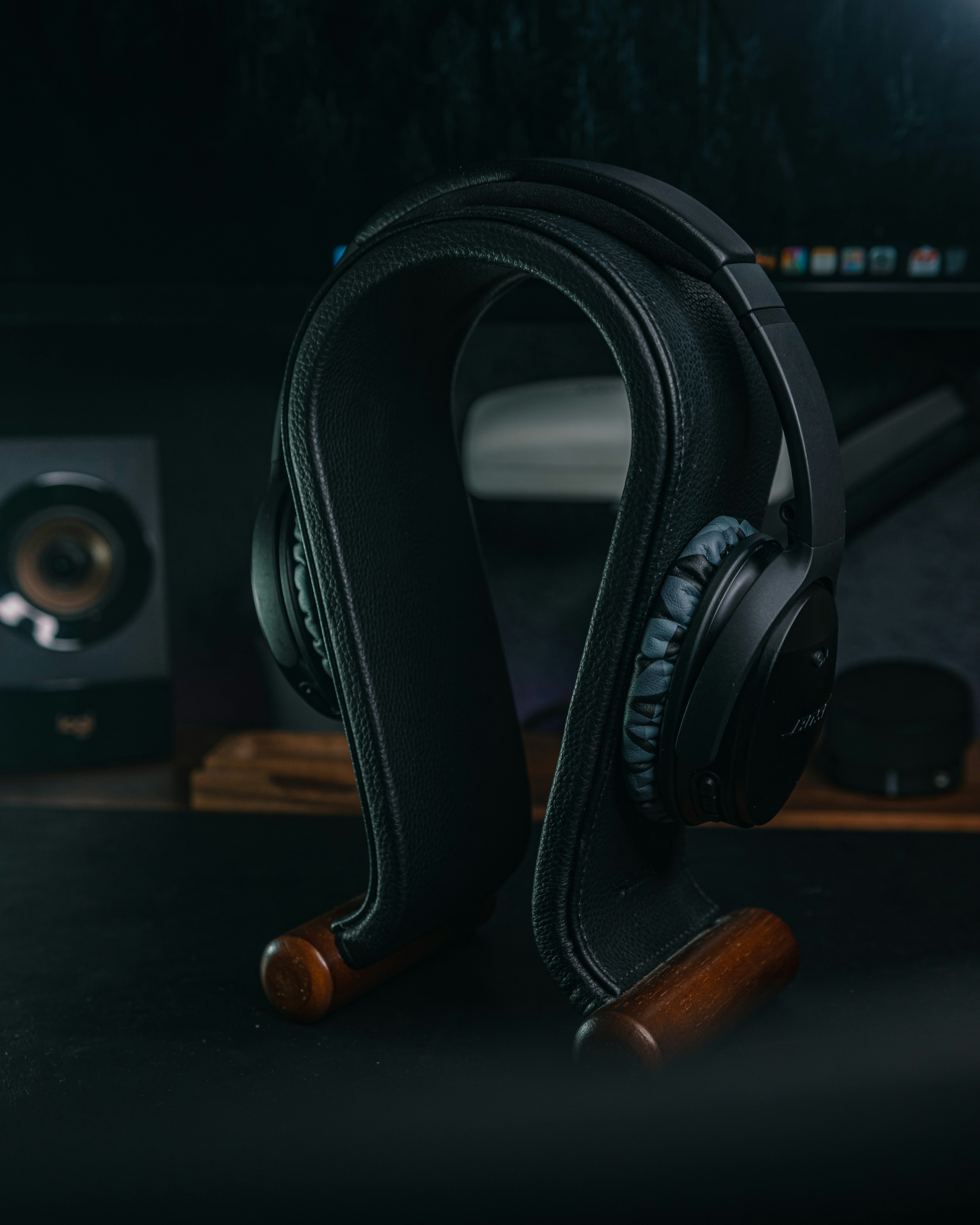 Over-ear noise-canceling headphones on a dark minimalist desk setup with monitor glow
