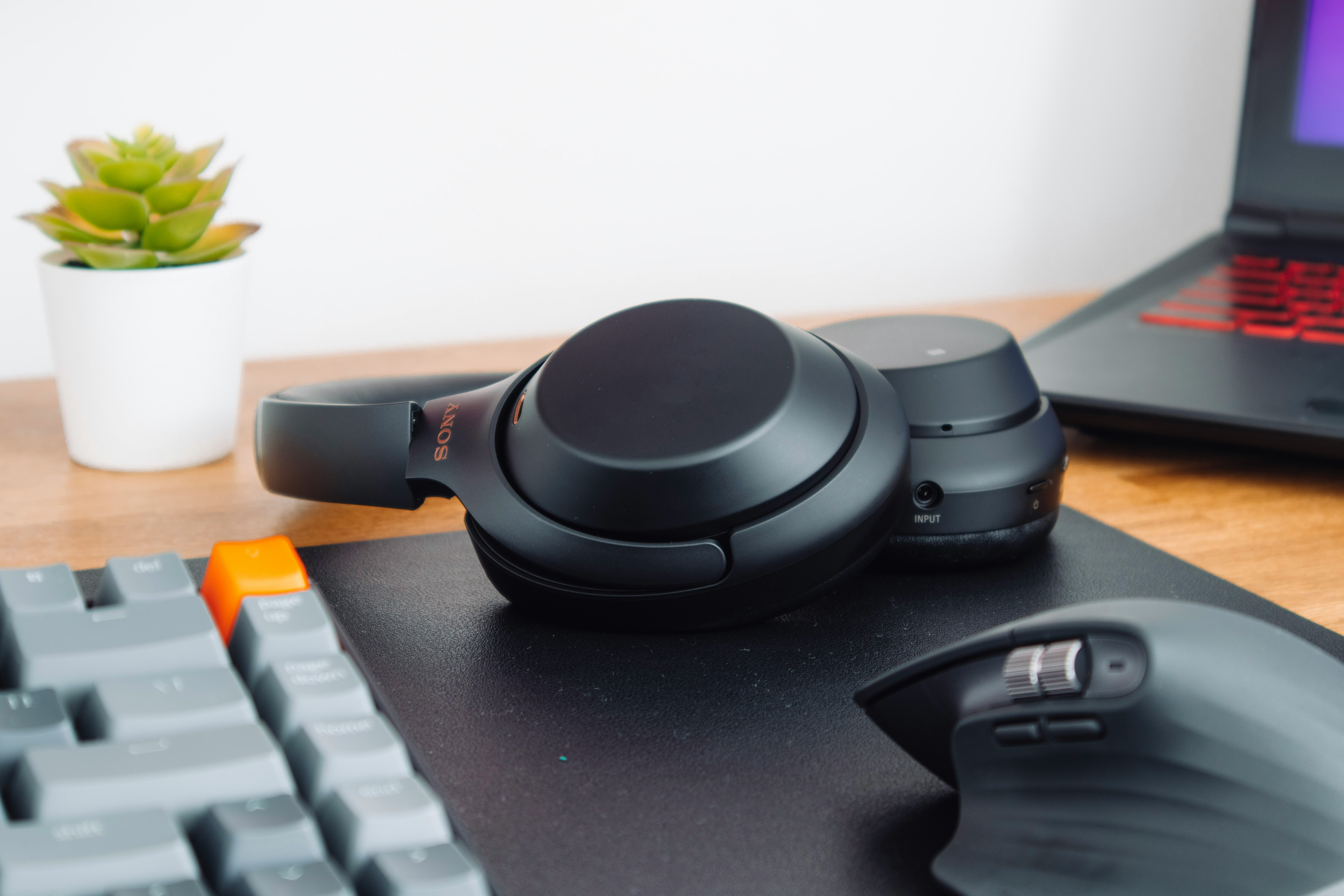 Work headset with boom microphone on a clean dark desk setup with monitor and keyboard