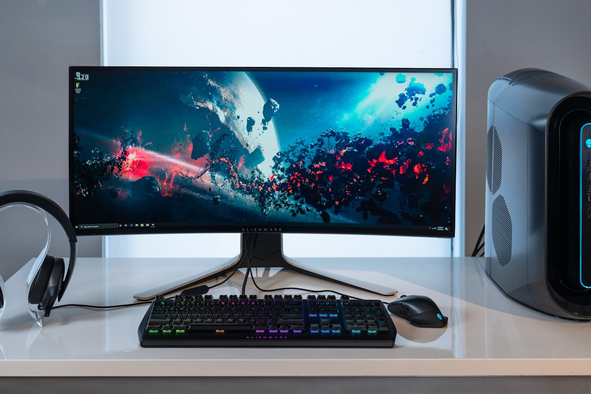 Black PC tower suspended under a standing desk in a dark mount bracket