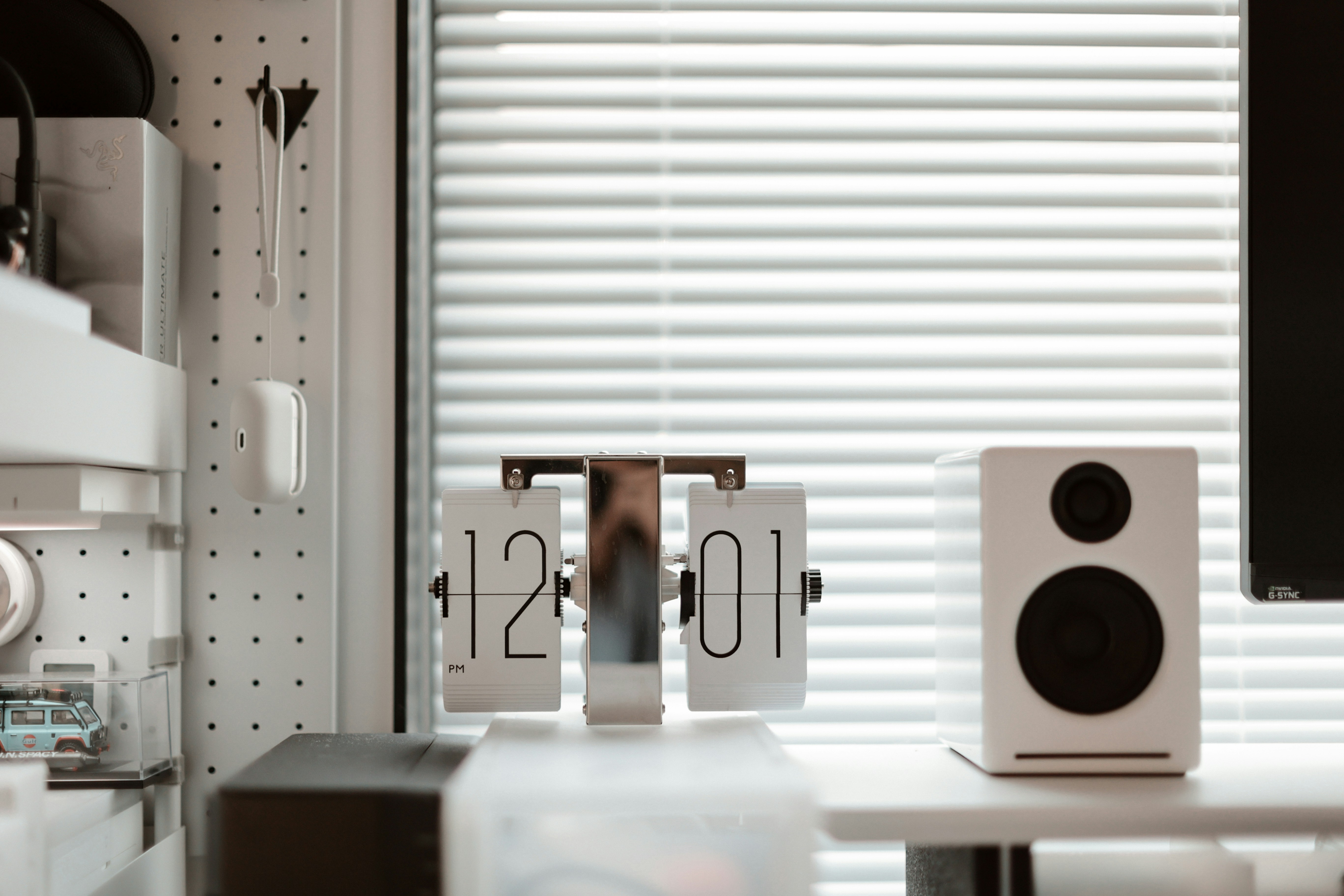 Minimal dark-themed desk setup with desktop speakers flanking a monitor, clean cable management, no headset in sight