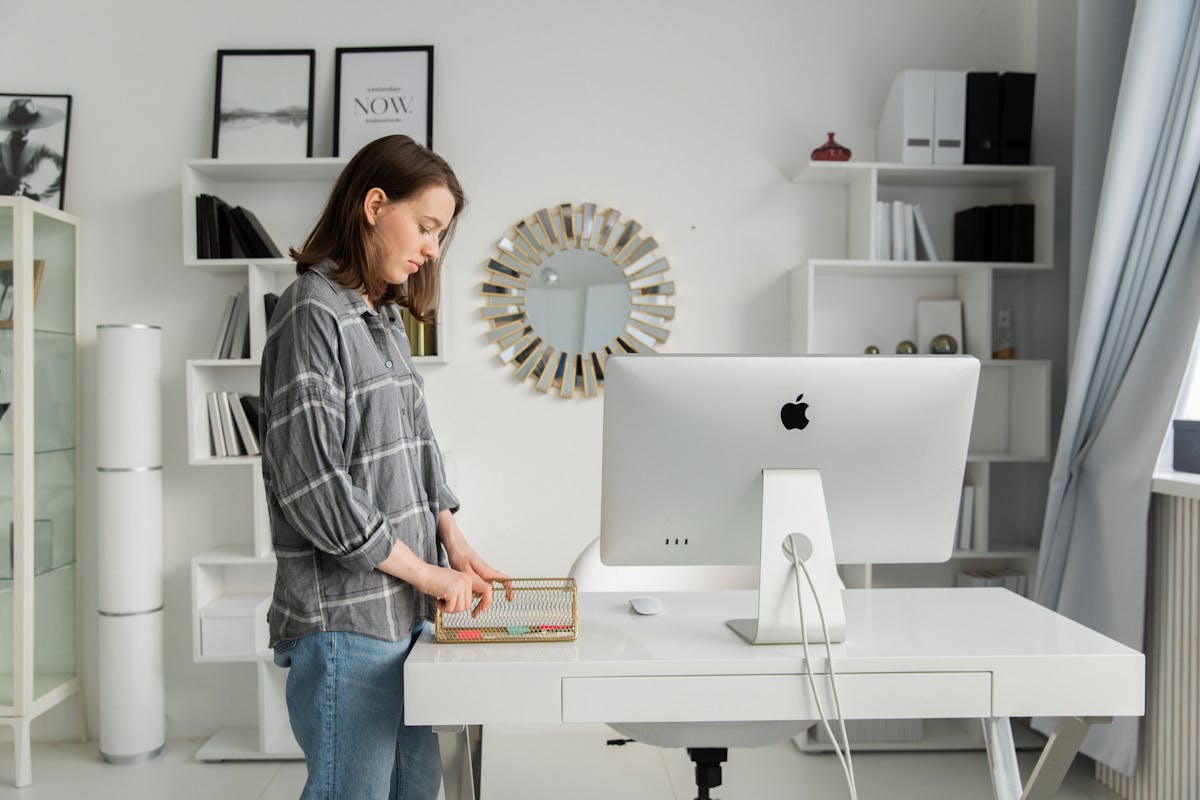 Person working at a modern height-adjustable standing desk in a home office