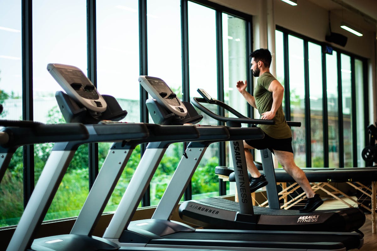 Person using treadmill for walking exercise at modern gym or home setup