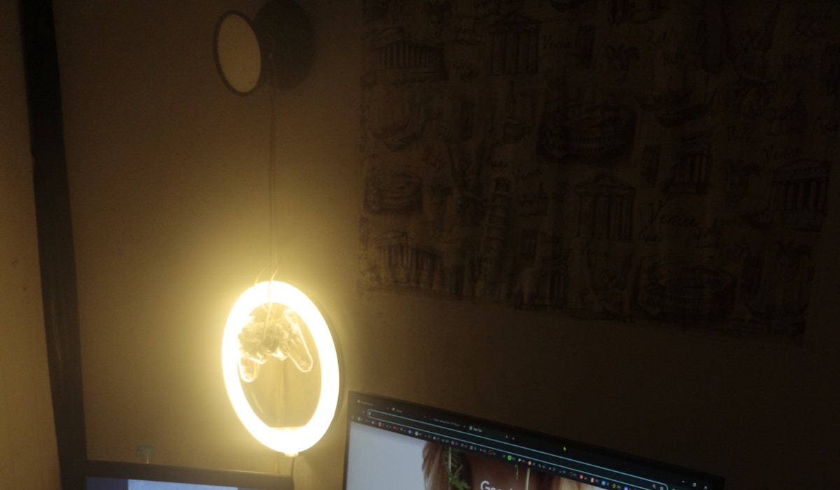 Minimalist dark-themed home office desk setup with monitor, keyboard, and clean workspace layout