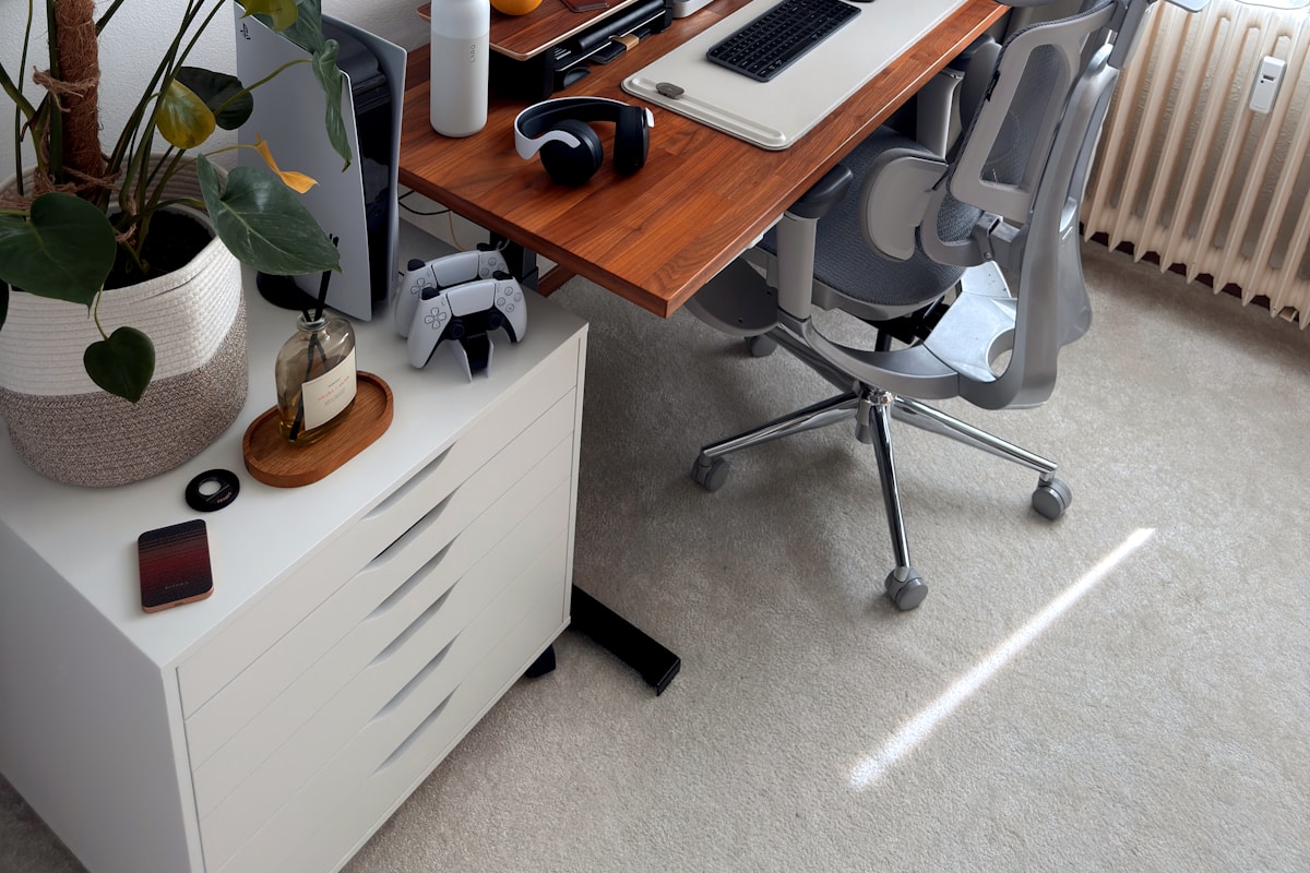 Leveling feet installed on standing desk legs with rubber grip base preventing wobble on hardwood floor